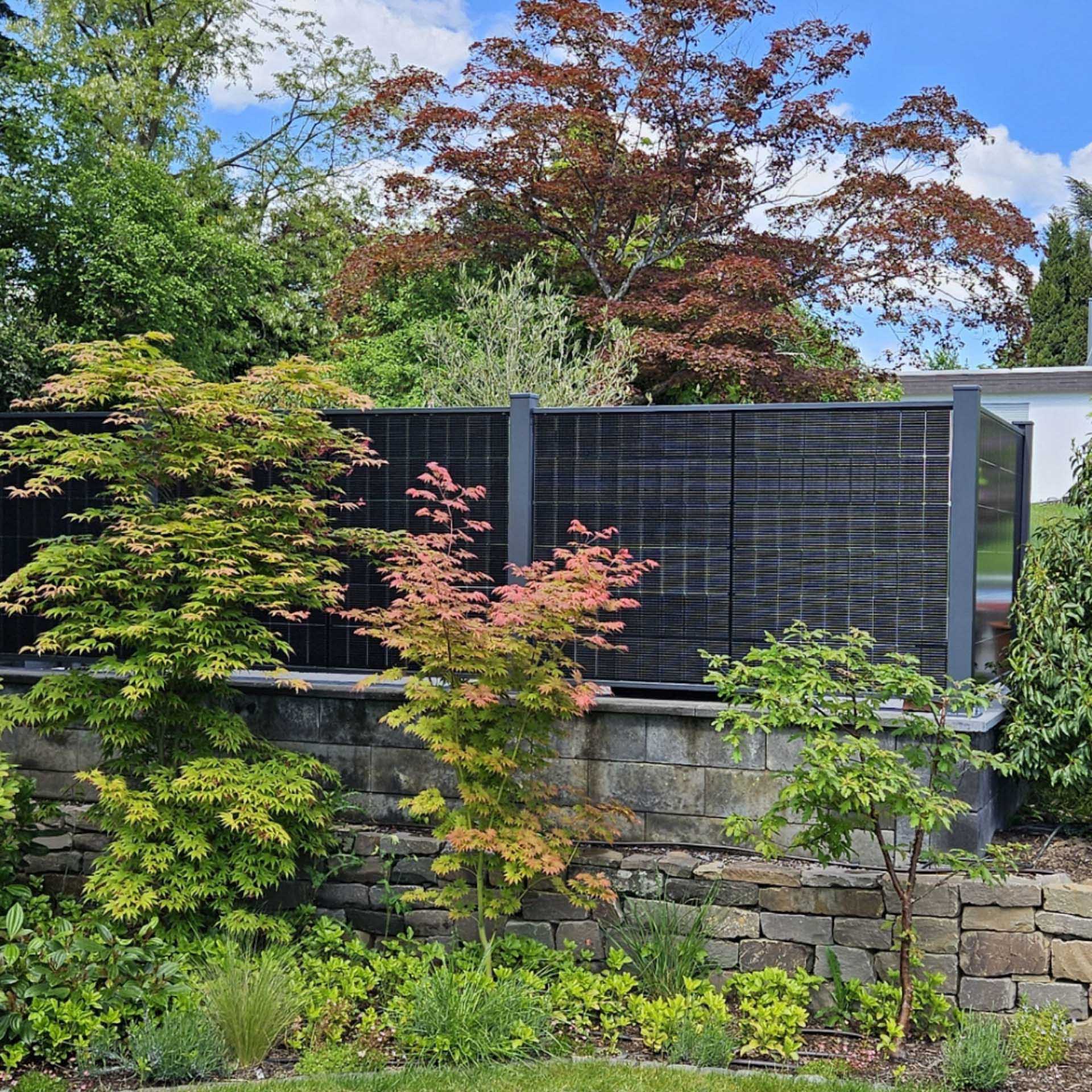 falagotti Solarzaun Puristica auf Gartenmauer mit flachem PV-Modul in RAL 7016